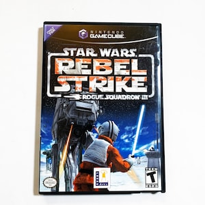 May include: A black Nintendo GameCube game case with a Star Wars: Rebel Strike - Rogue Squadron III game cartridge. The cover art features a Rebel pilot fighting an AT-ST walker in a snowy landscape.