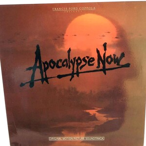 以下が含まれることがあります： フランシス・フォード・コッポラ監督の映画「地獄の黙示録」のサウンドトラックのヴィンテージ・レコード・カバー。カバーには、川の上を飛ぶヘリコプターと夕焼けのシーンが描かれている。