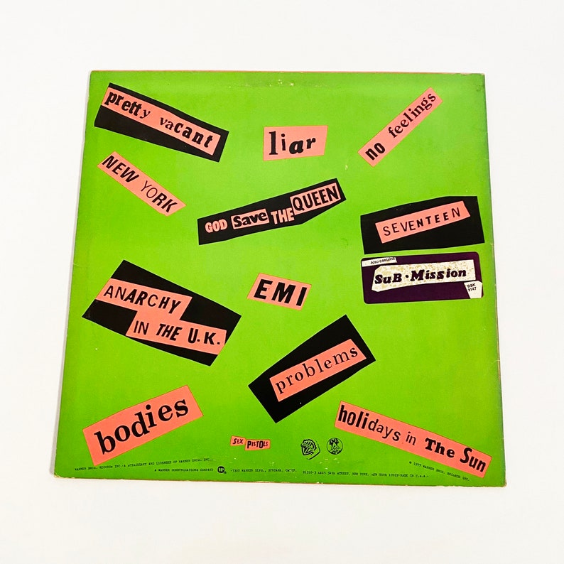 May include: Green vinyl record with pink and black text stickers. The stickers say "pretty vacant", "New York", "Anarchy in the U.K.", "bodies", "liar", "God Save The Queen", "EMI", "no feelings", "Seventeen", "Sub-Mission", "problems", and "holidays in The Sun".