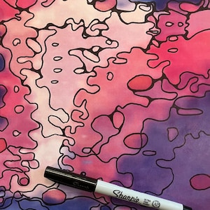 May include: Abstract watercolor painting with a vibrant mix of pink, purple, and blue hues, outlined with black ink. A black and white Sharpie Ultra Fine Point marker rests on the artwork, adding a contrasting element.