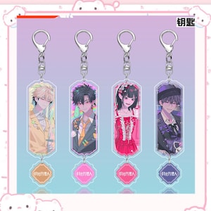 May include: Four anime-style keychains with silver metal hardware. Each keychain features a different character illustration in vibrant colors. The keychains have a rectangular shape with a small, light pink charm at the bottom with Japanese text.