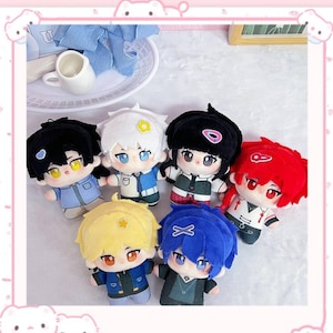 May include: A collection of six plush dolls with anime-style features. Each doll has a unique hairstyle and outfit, with colors including black, white, yellow, blue, and red. The dolls have large eyes and are posed in a group.