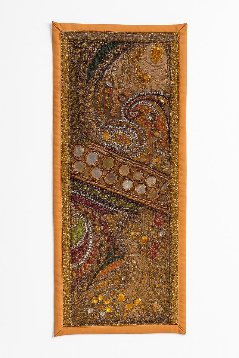 May include: A rectangular, ornate textile with a detailed paisley design. The central portion features a brown background with intricate patterns in gold, orange, green, and red. The border is a solid orange with gold trim, creating a rich, decorative piece.