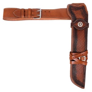 May include: A brown leather holster and belt set. The holster features a textured pattern and a silver star emblem. The belt has a buckle and multiple adjustment holes. The set is designed to be worn on the hip.