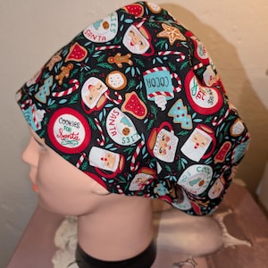 May include: A black scrub cap with a Christmas-themed design. The cap is patterned with Santa Claus, mugs of cocoa, gingerbread men, candy canes, and cookies. The words "Cookies for Santa" and "Santa" are also printed on the cap.