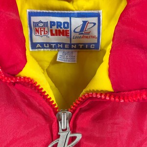 May include: Red and yellow vintage jacket with a full zipper. The jacket features the NFL Pro Line and Logo Athletic logos. The tag reads "AUTHENTIC" and "MADE IN KOREA".