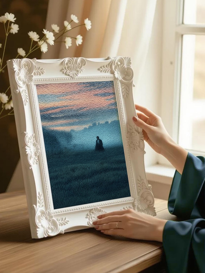 May include: A white, ornate picture frame holding a landscape painting of a person in a field. The painting features a blue and pink sky and a figure in the distance. The frame is held by a person with a dark green sleeve.
