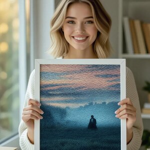 May include: A framed artwork featuring a landscape scene with a figure in the distance. The artwork has a white frame and depicts a field under a blue and pink sky. The image has a textured, painted appearance.