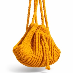 May include: A mustard yellow knitted drawstring bag with two thick, rope-like handles. The bag has a rounded, gathered shape and a textured, ribbed pattern. The drawstring closure is visible at the bottom.