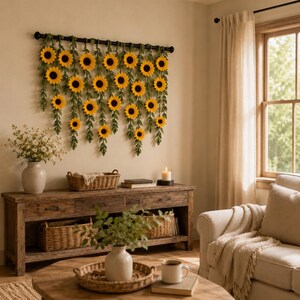 May include: A rustic living room scene featuring a wooden console table with woven baskets and a coffee table. A large sunflower garland hangs on the wall above the console. A vase of flowers and a lit candle add to the cozy atmosphere.