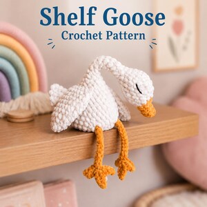 May include: A white crocheted goose plush with a textured surface, a curved neck, closed eyes, and orange feet. The text above the goose reads Shelf Goose Crochet Pattern. The goose is positioned on a wooden shelf next to a rainbow-colored object.