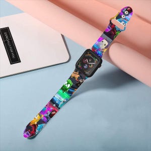 Puede incluir: Un reloj inteligente negro con una correa de silicona flexible decorada con un estampado gráfico multicolor de varios personajes de dibujos animados sobre un fondo oscuro con rayas de luz azul y morada de neón y formas geométricas.