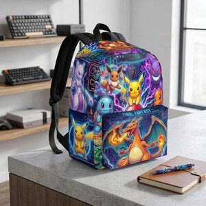 May include: A backpack featuring a vibrant, multi-colored graphic print of various animated creatures, including Pikachu, Eevee, and Charizard, set against a dark, electric-themed background. The front pocket displays the text FINAL FANTASY in white.