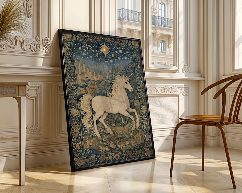 May include: Framed artwork featuring a white unicorn with a flowing mane and tail, set against a backdrop of a starry night sky and a castle. The artwork is framed in black and leans against a wall in a well-lit room.