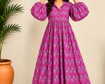 May include: A floor-length magenta dress featuring a repeating floral pattern in red and blue. The garment has a collared neckline, a gathered waist, and voluminous long sleeves with elasticized cuffs, creating a full, flowing skirt silhouette.