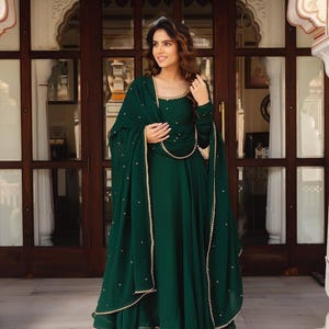 emerald green silk festive tiered anarkali dress Make a statement with this bold and versatile green fusion wear! Get two outfits in one and style it as you like with or without the jacket. A perfect blend of