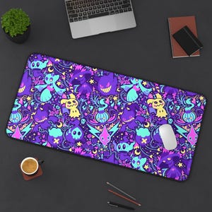 May include: A rectangular purple mousepad with a colorful pattern of cartoon characters, stars, and floral elements. The design features shades of purple, teal, yellow, and pink. A white computer mouse rests on the pad, with a laptop and other office supplies in the background.