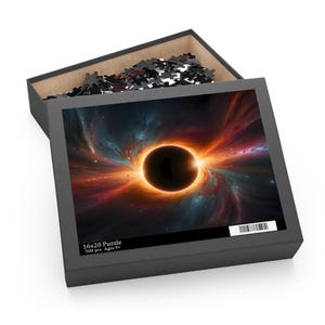 May include: A black puzzle box with a lid open, revealing a partially assembled puzzle. The puzzle image depicts a black hole with vibrant orange, red, and blue cosmic elements. The box reads "16x20 Puzzle" and "500 pcs Ages 9+".