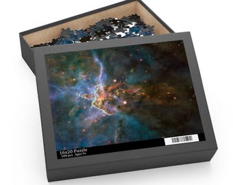 May include: A 16x20 inch puzzle box with a vibrant image of a nebula. The box is open, revealing puzzle pieces and the completed image. The box is black with the text "16x20 Puzzle 500 pcs Ages 9+".