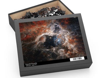 May include: A 16x20 inch puzzle box, open to reveal a partially assembled puzzle. The puzzle image depicts a colorful nebula with shades of red, orange, and blue. The box is black with the puzzle pieces visible inside.