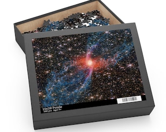 May include: A 16x20 inch puzzle box with a partially open lid, revealing puzzle pieces. The puzzle features a vibrant image of a nebula with red, blue, and white colors, set against a backdrop of stars. The box is dark gray.
