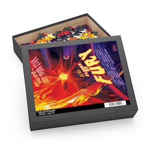 May include: A black puzzle box with a partially open lid, revealing a partially assembled puzzle. The box features the text "FURY" and "ANGRY YOUNG STAR" with a fiery, abstract design. The puzzle is 16x20 inches and contains 500 pieces.