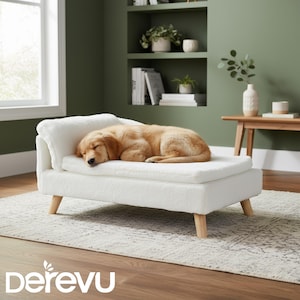Puede incluir: Un golden retriever dormido descansa sobre una cama para perros blanca con patas de madera. La cama tiene una superficie de felpa texturizada y un pequeño respaldo. La cama para perros está sobre una alfombra estampada en una habitación con paredes verdes.