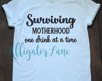 Surviving Motherhood One Drink at a Time Graphic T Shirt Mommyhood Funny Shirts Moms that Drink