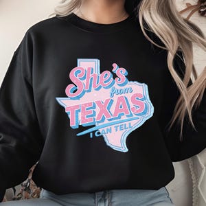 May include: A white ceramic mug with a black handle and the text "But first, coffee" in a handwritten style. The mug is on a white surface. The mug is 4 inches tall.