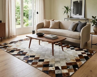 Könnte beinhalten: Ein rechteckiger Teppich mit einem geometrischen Patchwork-Muster aus quadratischen Fliesen in Braun-, Schwarz-, Weiß- und Grautönen. Der Teppich besteht aus einzelnen Stücken von Tierhaut, was eine strukturierte Oberfläche mit abwechslungsreichen natürlichen Farbtönen erzeugt.
