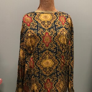 May include: A long-sleeved blouse with a black background and a gold and red paisley pattern.