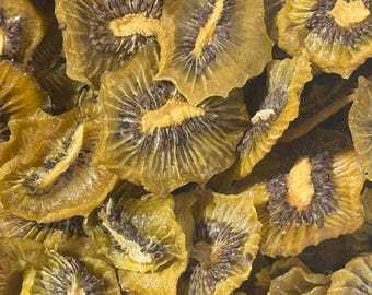 May include: A close-up shot of dried kiwi fruit slices. The slices are a mix of yellow and brown, with a star-like pattern in the centre. The texture appears slightly translucent, highlighting the natural details of the fruit.