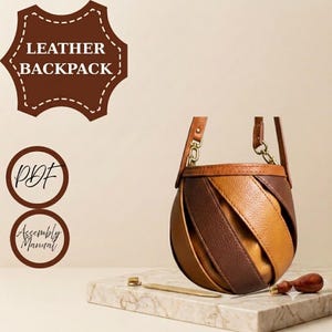 Puede incluir: Una mochila de cuero redonda con tiras diagonales alternas de cuero marrón oscuro y color canela. El bolso tiene dos correas de cuero finas sujetas con herrajes de metal dorado. El texto en la imagen dice LEATHER BACKPACK, PDF y Assembly Manual.