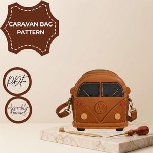 May include: A brown leather bag shaped like a vintage van with black windshields, a central VW logo, and two circular headlights. The text CARAVAN BAG PATTERN, PDF, and Assembly Manual are visible. A metal tool and an awl are placed nearby.