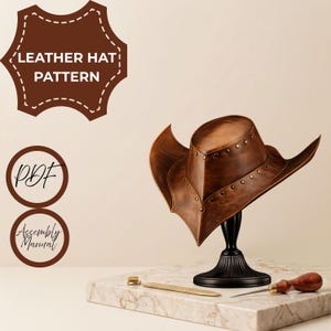 May include: A brown leather hat with a pointed brim and metal studs, displayed on a black stand. The image includes text reading LEATHER HAT PATTERN, PDF, and Assembly Manual, alongside a metal tool and a wooden-handled awl on a marble base.