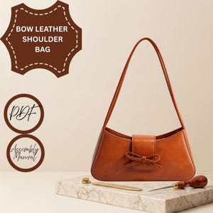 May include: A tan shoulder bag featuring a central bow detail on the front flap and a single shoulder strap. Text on the image reads: BOW LEATHER SHOULDER BAG, PDF, and Assembly Manual. A metal tool and a wooden-handled awl are visible.