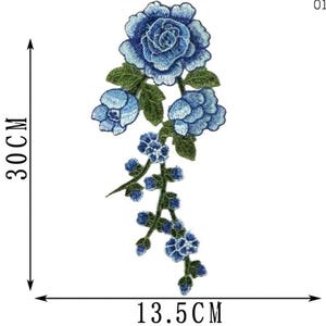 May include: Embroidered blue floral applique, approximately 11.8 inches long and 5.3 inches wide. The design features a large rose and several smaller blossoms with green leaves. The applique is labeled "01#".