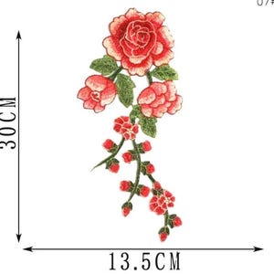 May include: Embroidered floral patch featuring a large red rose with green leaves and smaller red buds. The patch measures 11.8 inches in height and 5.3 inches in width. Ideal for adding a decorative touch to clothing or accessories.