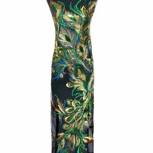 May include: A black dress form displays a long, sleeveless dress. The dress features a detailed peacock feather design in green, gold, and blue. The fabric is sheer, with the design covering the front of the dress.