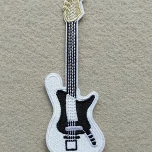May include: Embroidered patch of an electric guitar. The patch features a white outline with a black body and neck, and a gold-colored headstock. The strings are black and white.