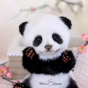 May include: A plush panda bear with a white body, black markings, and a friendly expression. The panda has black ears, paws, and eye patches. The text "With love Lastenka" is printed on the panda's chest. The bear is sitting with its paws raised.