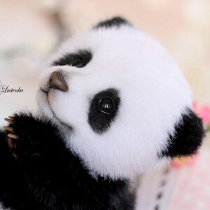 May include: A handmade panda bear plush toy with black and white fur, black eyes, and a brown nose. The panda is looking up, with its paws extended. The text "With love, Lazienka" is visible.