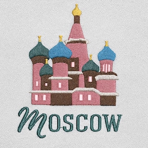 May include: Embroidered design of St. Basil's Cathedral in Moscow, featuring pink, brown, teal, and gold colors. The word "Moscow" is written in teal script below the building. The design is on a white background.