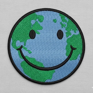 May include: Embroidered patch with a smiling Earth design. The patch has a blue background with green continents, black eyes, and a black curved smile. The patch is circular with a black border.