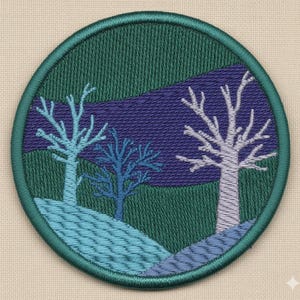 Könnte beinhalten: Runder, gestickter Aufnäher mit einer Landschaft mit drei stilisierten Bäumen. Das Design umfasst einen dunkelblauen Himmel, grüne und blaue Hügel und einen türkisfarbenen Rand.