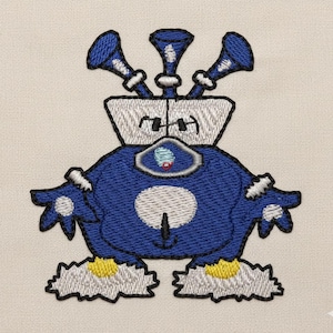 May include: Embroidered patch featuring a blue robot-like character with three horn-like protrusions on its head. The character has white accents, a white belly, and yellow details on its feet. The patch is on a beige fabric.