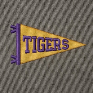 May include: Embroidered pennant in a triangular shape, featuring the word "TIGERS" in purple lettering on a gold background. The pennant has purple vertical accents and is set against a textured gray backdrop.