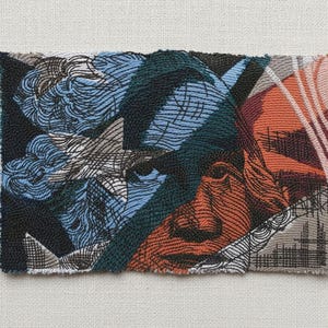 May include: A rectangular textile art piece featuring a face composed of various colors and textures. The artwork incorporates shades of blue, orange, black, and gray, with visible woven and stitched details. The design includes abstract shapes and lines.