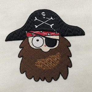 Op de afbeelding: Geborduurd piratengezicht met een zwarte hoed met een doodskop en gekruiste botten, een rode bandana en een ooglapje. De piraat heeft een bruine baard en een neutrale uitdrukking. Het ontwerp staat op een witte achtergrond.