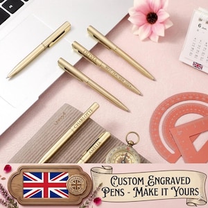 May include: Gold-coloured custom engraved pens with names and "Best Teacher 2024" text. The pens are displayed on a pink surface with a laptop, calendar, compass, and protractor. The image also includes a banner that says "Custom Engraved Pens - Make it Yours."
